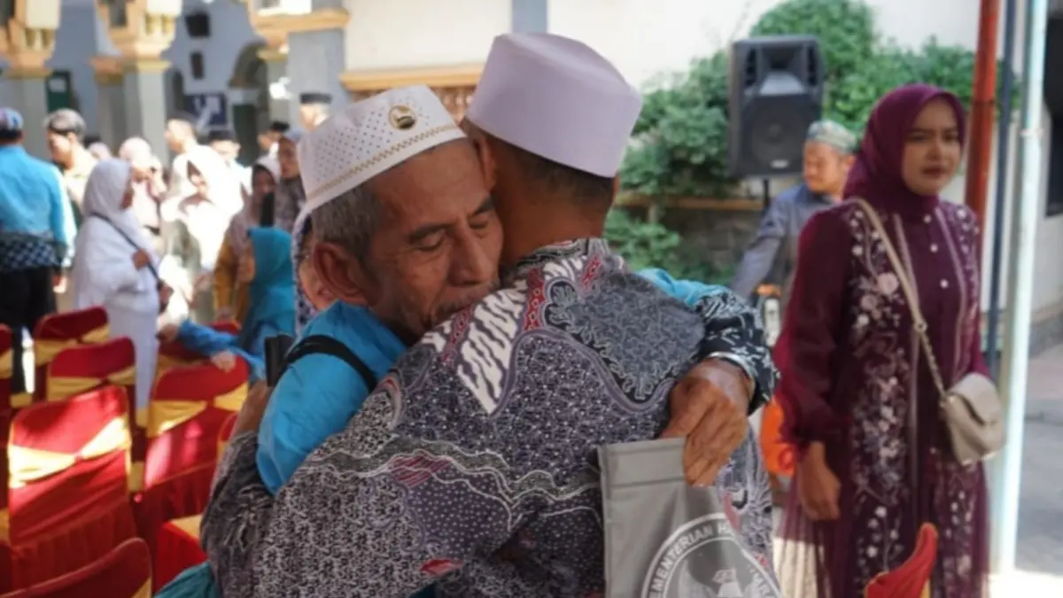 Salah satu jemaah haji Tulungagung memeluk sanak keluarganya yang menjemput di KBIHU Al Hikmah Melathen pada Minggu (28/6) pagi. (DR PERDANA/RADAR TULUNGAGUNG)
