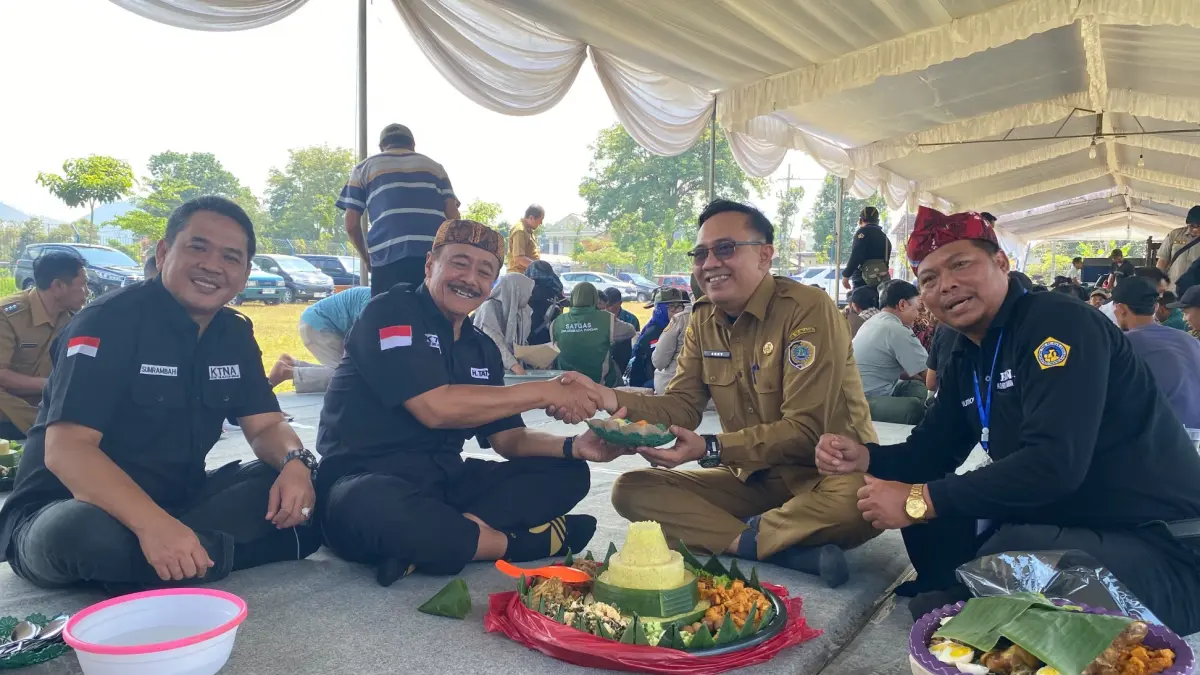 Ketua KTNA Tulungagung Tatang Suhartono didampingi Ketua KTNA Jawa Timur Sumrambah menyerahhkan potongan tumpeng kepada Kepala DKP Tulungagung Sony Welly Ahmadi, (DR PERDANA/RADAR TULUNGAGUNG)