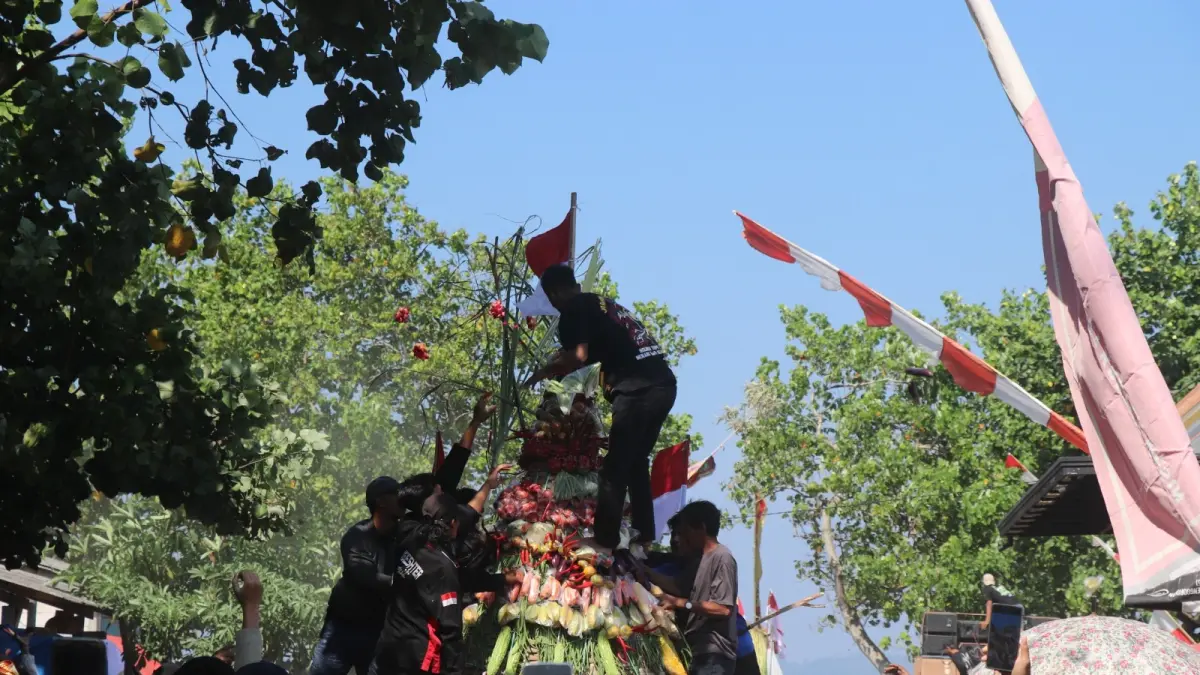 Warga Dusun Sidem, Desa Besole, Kecamatan Besuki, berebut gunungan di ritual adat Larung Sembonyo, Minggu (12/7/2026).(RAHIIQ AL BACHRI/RADAR TULUNGAGUNG) 