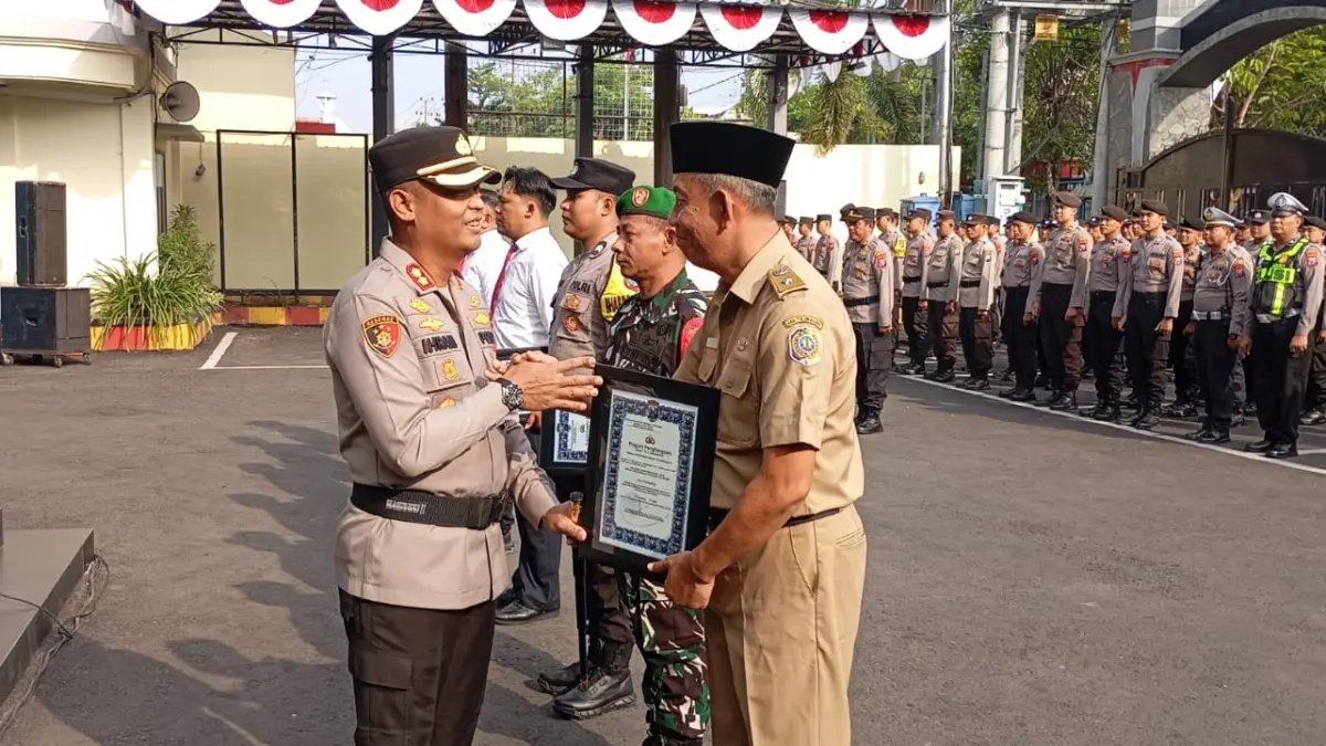 Penyerahan penghargaan oleh Kapolres Tulungagung AKBP Ihram Kustarto kepada Tiga Pilar Desa Karangtalun dalam apel yang digelar di Markas Polres Tulungagung, Senin (13/7/2026).