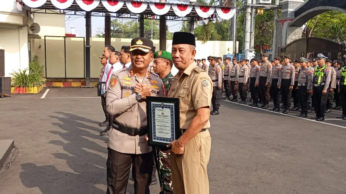 Penyerahan penghargaan oleh Kapolres Tulungagung AKBP Ihram Kustarto kepada Tiga Pilar Desa Karangtalun dalam apel yang digelar di Markas Polres Tulungagung, Senin (13/7/2026). 