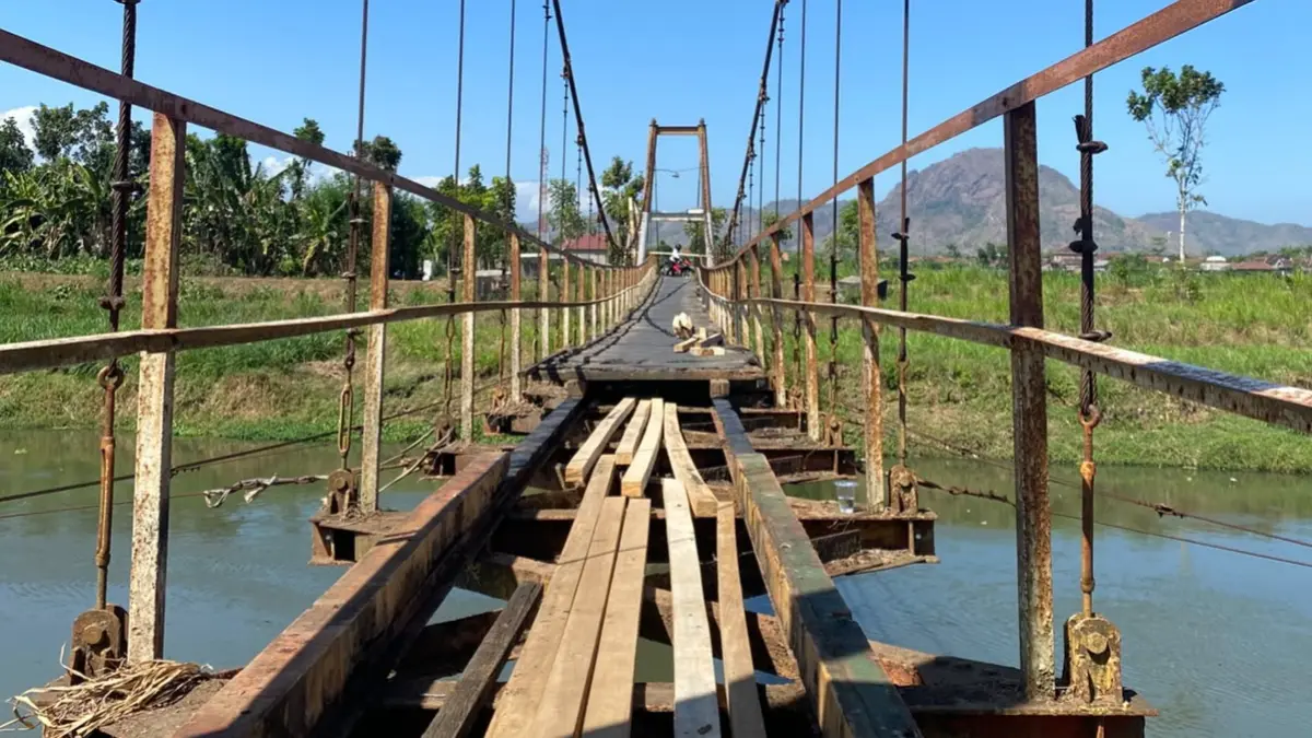 Jembatan gantung di Desa Kendalbulur, Kecamatan Boyolangu, Tulungagung direhab secara swadaya desa memanfaatkan CSR dari salah satu pabrik rokok. (DR PERDANA/RADAR TULUNGAGUNG)