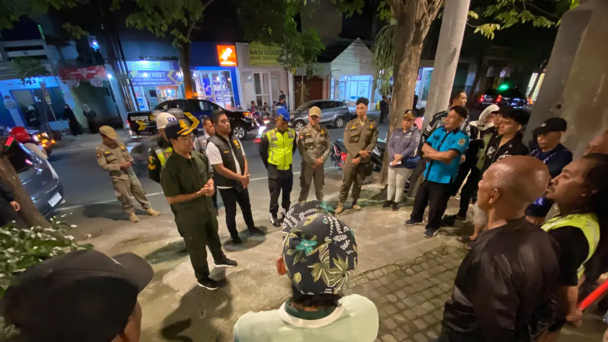 Kabid Sarpras Dishub Tulungagung Mahendra Sulistiawan memberikan penjelasan kepada juru parkir di sekitar Jalan Ahmad Yani Barat pada Rabu malam (22/7). (DR PERDANA/RADAR TULUNGAGUNG)