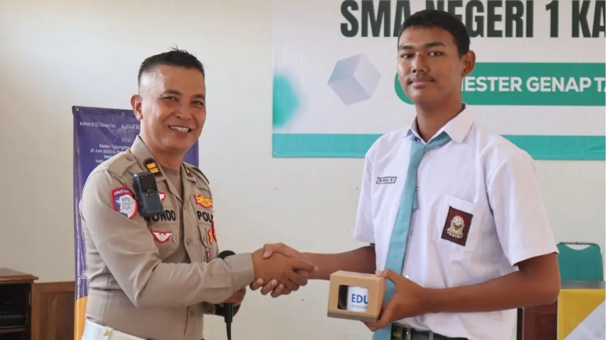 Pemberian hadiah dari Kanit Kamsel Satlantas Polres Tulungagung Iptu Sunondo kepada siswa SMAN 1 Kauman.