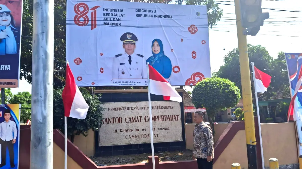 Camat Campurdarat Tri Wantoro ikut memasang beberapa bendera merah putih dalam rangka menyambut Hari Kemerdekaan ke-81 di kantor Kecamatan setempat. (KECAMATAN CAMPURDARAT)
