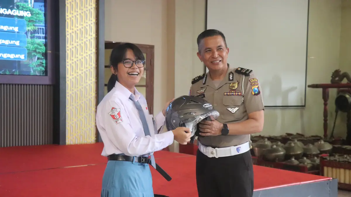 Kanit 
Kamsel Satlantas 
Polres Tulungagung 
Iptu Sunondo 
memberikan 
cenderamata ke siswi 
Smariduta.