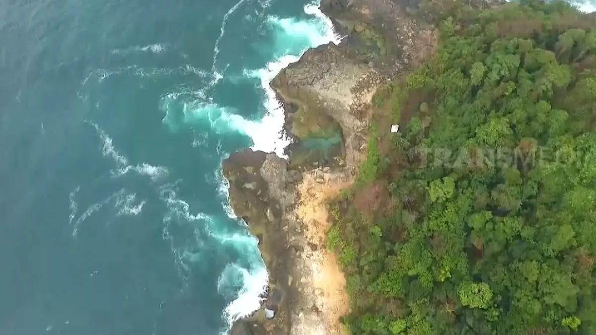 Pantai Kedung Tumpang Tulungagung menawarkan laguna alami yang eksotis dengan jalur ekstrem. Simak pesona wisata, akses menuju lokasi, serta bahaya ombak yang wajib diwaspadai.(SC Youtube)