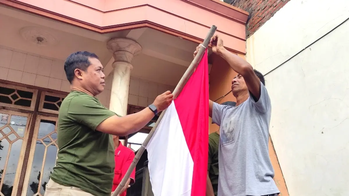 Tak hanya bagi-bagi, Ketua PWI Tulungagung Wiwieko Dharmaidiningrum ikut membantu warga di Desa Panggungrejo, Kecamatan Kauman memasang bendera merah putih, Sabtu (8/8). (SANDY YUWANA)