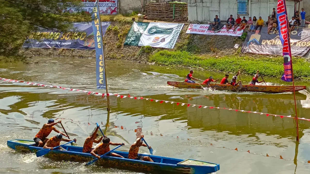 Dua perahu dayung bersaing menuju garis finis di perlombaan menyambut HUT Ke-81 RI di aliran Sungai Ngrowo, Minggu (9/8/2026).(RAHIIQ AL BACHRI/RATU)