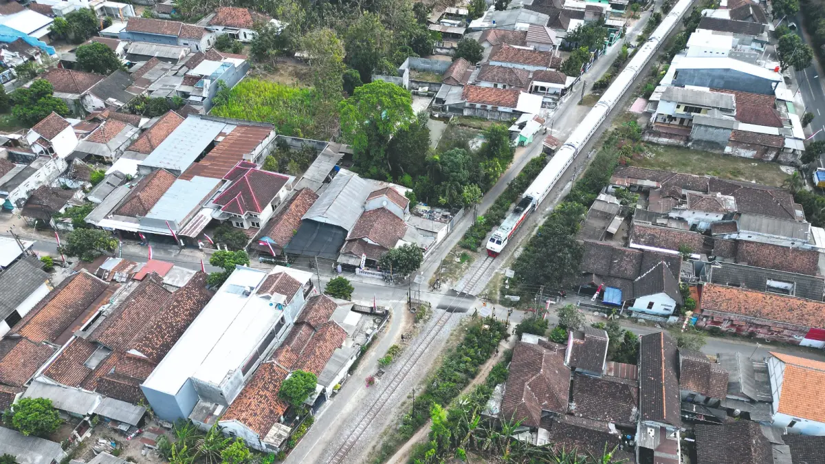 Foto udara perlintasan kereta api di Desa Gilang, Kecamatan Ngunut, Tulungagung, yang batal ditutup PT KAI setelah mendapat penolakan dari warga karena berpotensi mengganggu aktivitas warga.(ANGGI SEPTIAN/RATU)