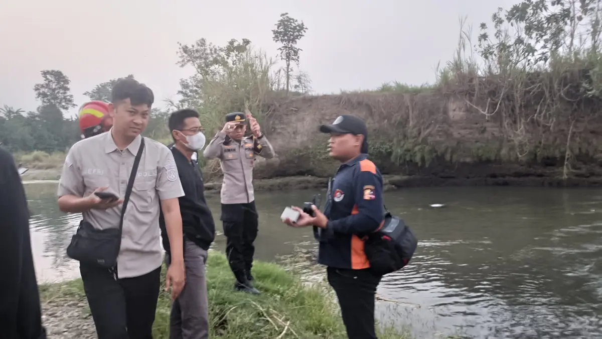 Petugas gabungan bersama warga mengevakuasi jenazah warga Pulosari yang ditemukan mengapung di aliran Sungai Brantas, Ngunut, Senin (17/8).(POLRES TULUNGAGUNG)