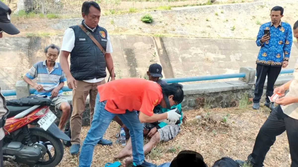 Petugas melakukan pemeriksaan terhadap korban yang diduga meninggal setelah tersengat aliran listrik saat memancing di kawasan Waduk Wonorejo, Pagerwojo, Senin (17/8).(POLRES TULUNGAGUNG)
