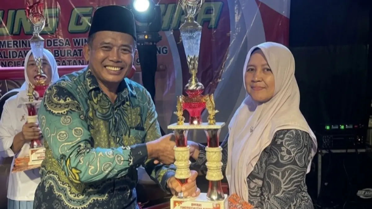 Kepala Desa Winong, Sutejo, menyerahkan langsung piala dan piagam penghargaan sebagai apresiasi pada guru Winong Raya di malam Panggung Gembira.