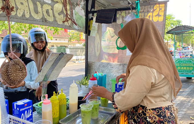 GIRANG: Seorang pedagang di Jalan Ahmad Yani Timur saat meramu dagangannya untuk pembeli.