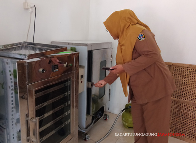 TUNGGU BAHAN: Leni Puji Astuti menunjukkan mesin produksi teh dari rambut jagung. (YUSRIN RAHMAWATI/RADAR BLITAR)
