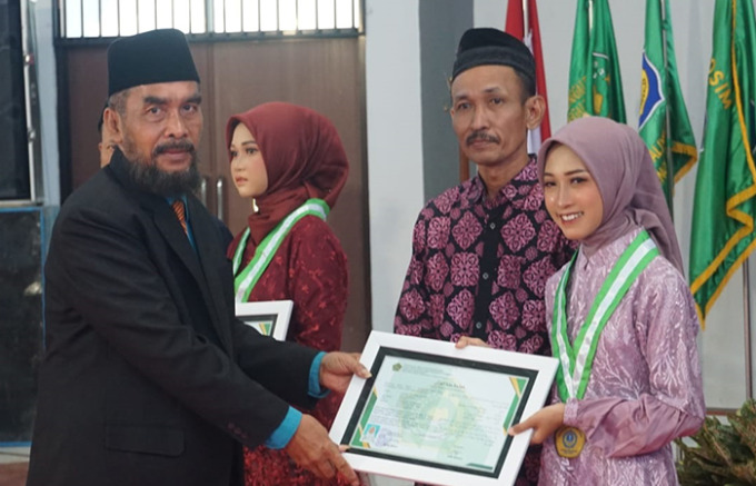 BERPRESTASI: Salah satu wisudawati mendapat penghargaan dari Kepala Madrasah Aliyah Negeri 1 Trenggalek Agung Suyoto MPdI dengan menjadi hafizah Quran di sekolah. (FOTO: BIMA FAISAL/RADAR TRENGGALEK)
