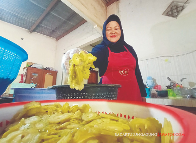PEKERJA KERAS: Tarmini sibuk menggoreng keripik pare di dapurnya. Olahan keripik dari sayuran ini ramai dibeli saat perayaan hari libur maupun Lebaran. (MOCHAMMAD LUKI AZHARI/RADAR BLITAR)