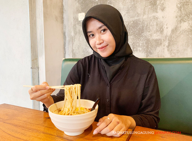 NIKMAT: Niken Indriasari menikmati seporsi ramen pedas. Menurutnya, kuah gurih legit ramen itu berasal dari kaldu ayam. (FOTO-FOTO: MOCHAMMAD LUKI AZHARI/RADAR BLITAR)