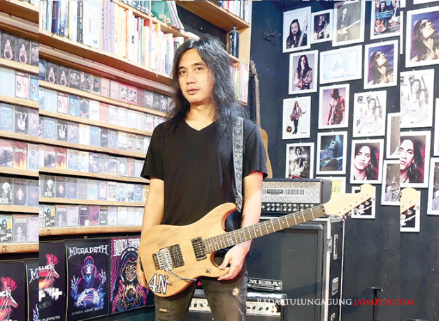 TERUS KEMBANGKAN SKILL: Handika Rosadi berpose dengan salah satu gitar miliknya. Dia memilih menekui musik. (DONI SETIAWAN/RADAR BLITAR)