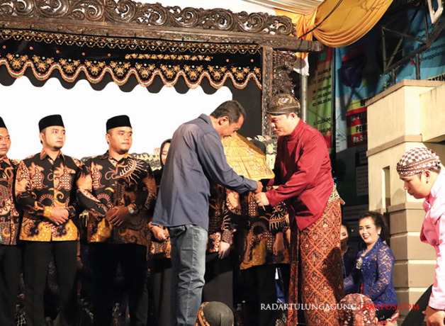 SIMBOLIS: Kepala Desa Ngaglik Agus Utomo menyerahkan gunungan kepada dalang Ki Eko Kondho Prisdianto. (FOTO-FOTO: BUDIONO/RADAR BLITAR)