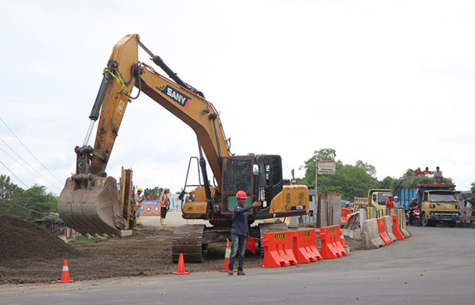 MASIH PROSES: Pekerja saat menggunakan ekskavator untuk mengerjakan proyek Jembatan Ngujang 1, kemarin (7/6). (foto: SATRIA CAHYONO/RADAR TULUNGAGUNG )