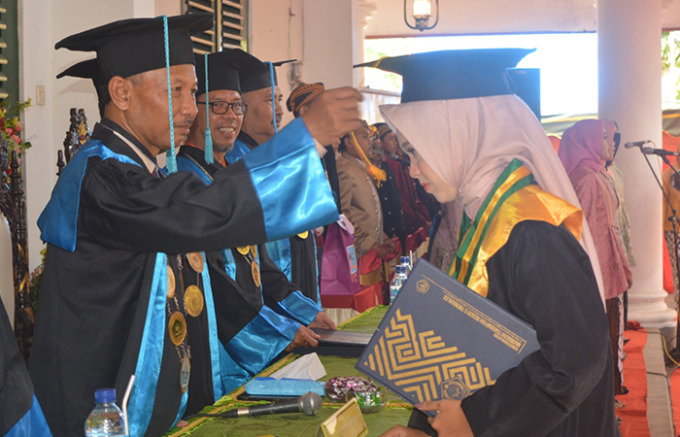 DIWISUDA: Kepala MTsN 5 Trenggalek Wiratno  MPd, memindahkan tali kucir di kepala siswinya sebagai tanda kelulusan.
