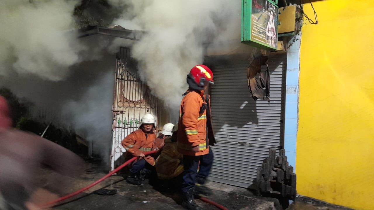 Petugas melakukan pembasahan di lokasi kebakaran Bulak Banteng, Surabaya (IST)