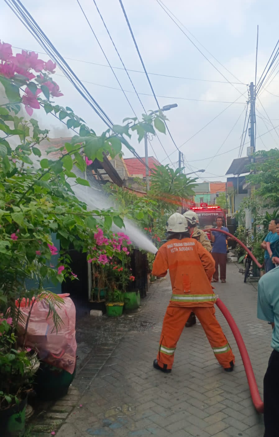 SIGAP: Petugas melakukan pembasahan di rumah Jalan Karangrejo Sawah II, Selasa (20/6).
