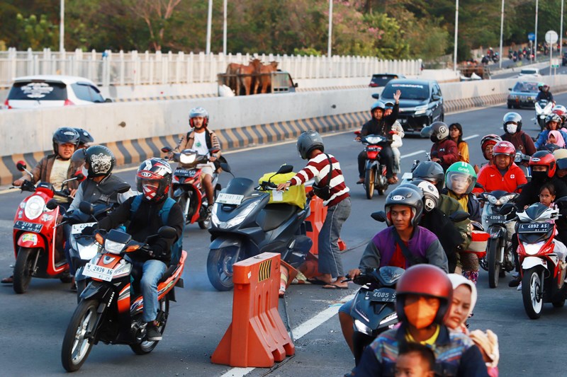KECANTOL: Seorang pemotor tersangkut tali pembatas yang memisahkan jalur motor dan mobil karena berusaha menerobos di Jembatan Suramadu, Rabu (28/6). (ANDY SATRIA/RADAR SURABAYA)
