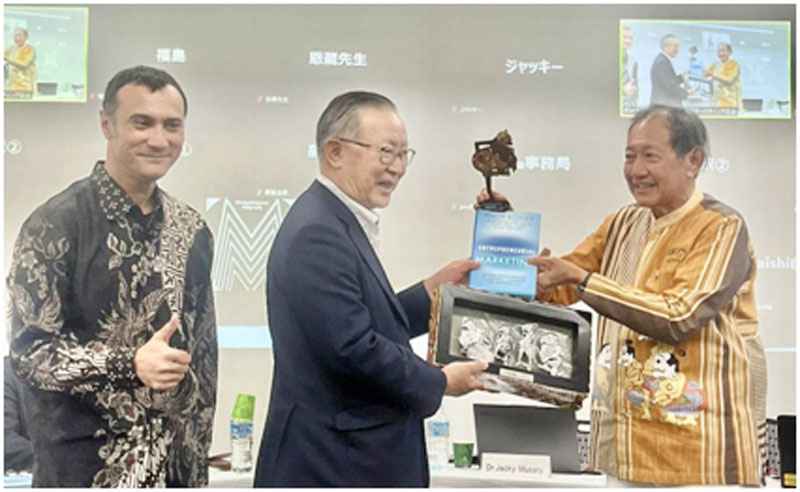 Hermawan Kartajaya (kanan) memberikan cinderamata patung Punokawan kepada Tsunehiro Fukushima selaku perwakilan Japan Marketing Association disaksikan CEO Markplus Inc., Jacky Mussry. (ISTIMEWA)