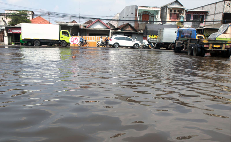 AIR PASANG: Kawasan Jalan Kalianak tertutup genangan air laut yang naik ke jalan hingga masuk ke permukiman warga. (ANDY SATRIA/RADAR SURABAYA)
