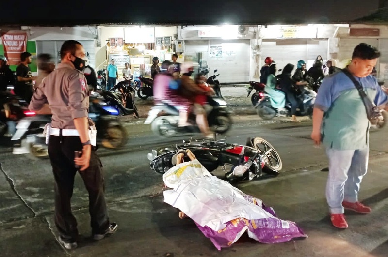 NAHAS: Jenazah Budi Santoso ditutupi karung seusai kecelakaan di Jalan Benowo, Selasa (4/7) malam. (ISTIMEWA)