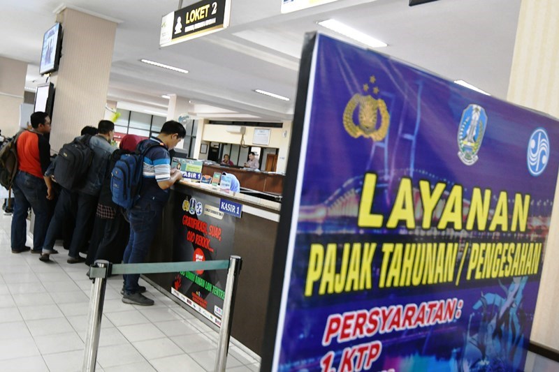TAAT PAJAK: Warga melakukan pengurusan pajak kendaraan bermotor di Samsat Manyar Surabaya. (SURYANTO/RADAR SURABAYA)