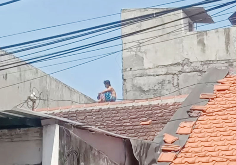 SIGAP: Petugas gabungan melakukan upaya evakuasi AH yang hendak mencoba bunuh diri terjun dari atap rumah warga Jalan Kupang Jaya. (ISTIMEWA)