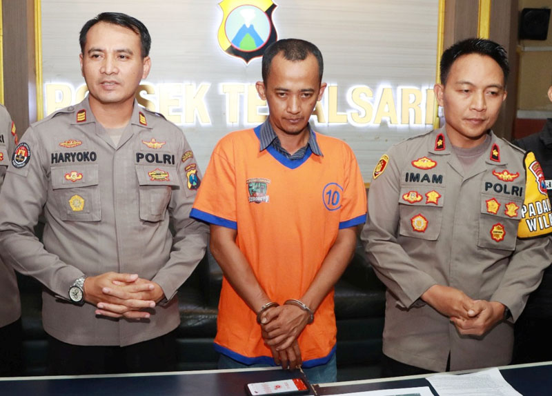 AKAL BULUS: Tersangka Diki Arfian diamankan di Mapolsek Tegalsari, Surabaya, Selasa (25/7), terkait penipuan penerimaan siswa baru. (SURYANTO/RADAR SURABAYA)