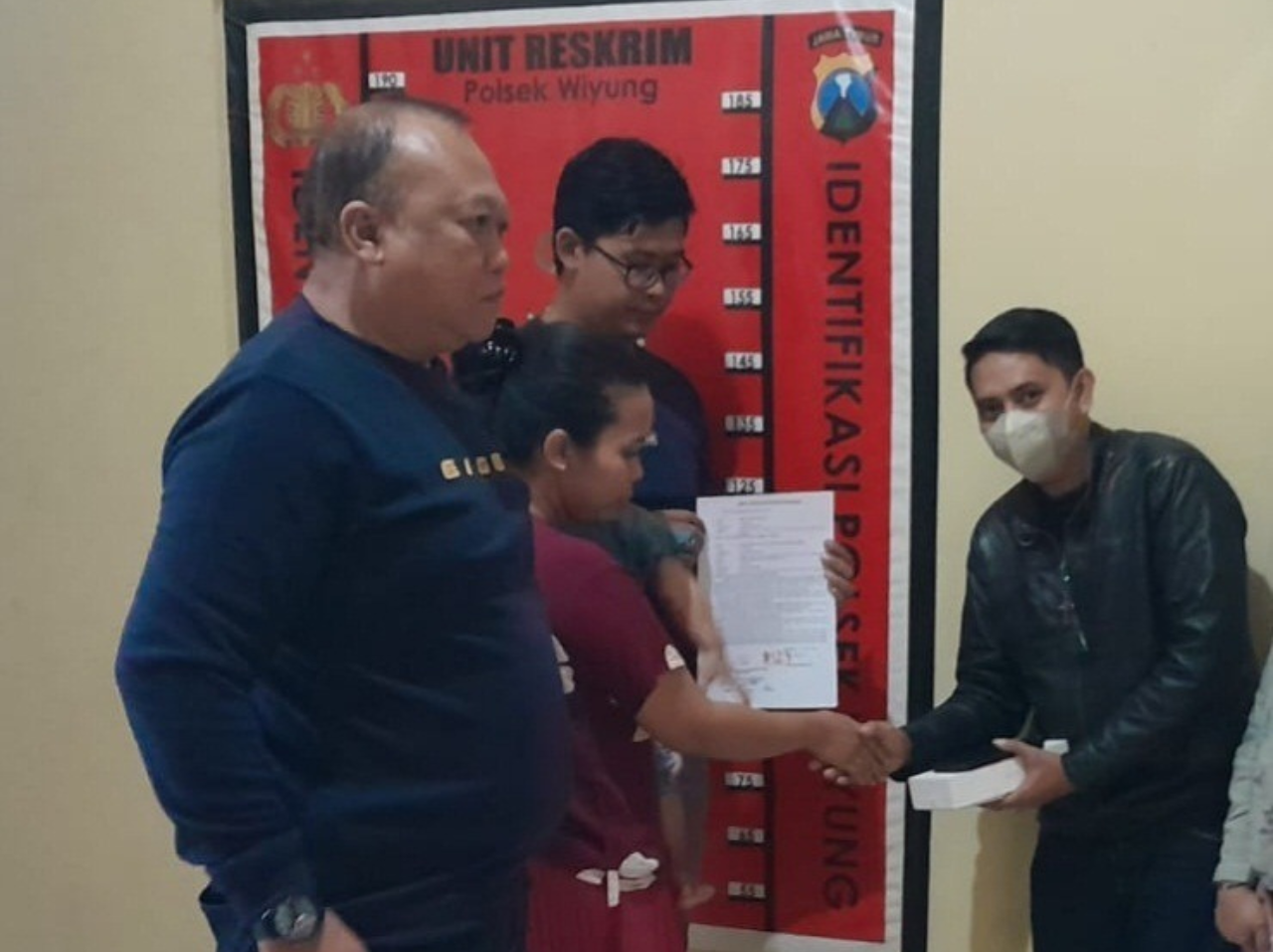 SERAHKAN HP: Desy Khifayatul Alief menyerahkan HP kepada korban di Mapolsek Wiyung. (ISTIMEWA)