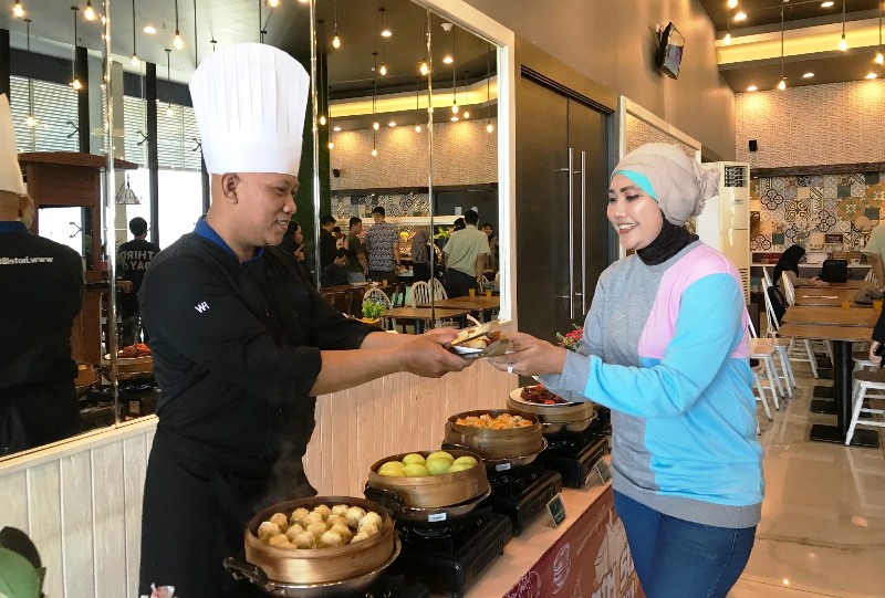 DIMSUM LOVER: Tia, salah satu tamu yang menikmati aneka dimsum buatan chef Mario di promo Delicious Sunday Hotel 88 Kedungsari Surabaya. (NURUL AFIAH/RADAR SURABAYA)