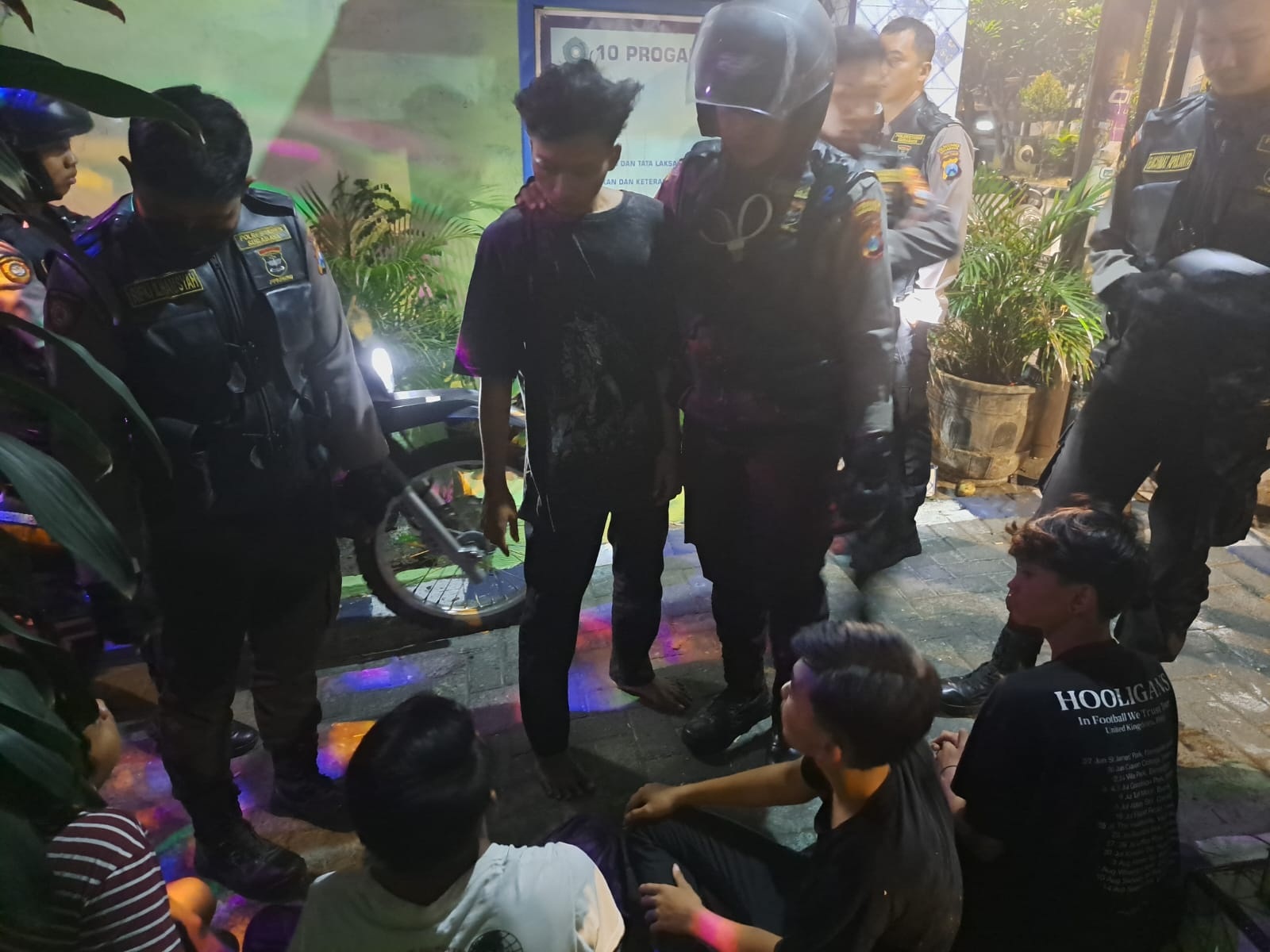 MENCURIGAKAN: Petugas mengamankan sejumlah remaja di Jalan Ngagel, Surabaya. (ISTIMEWA)