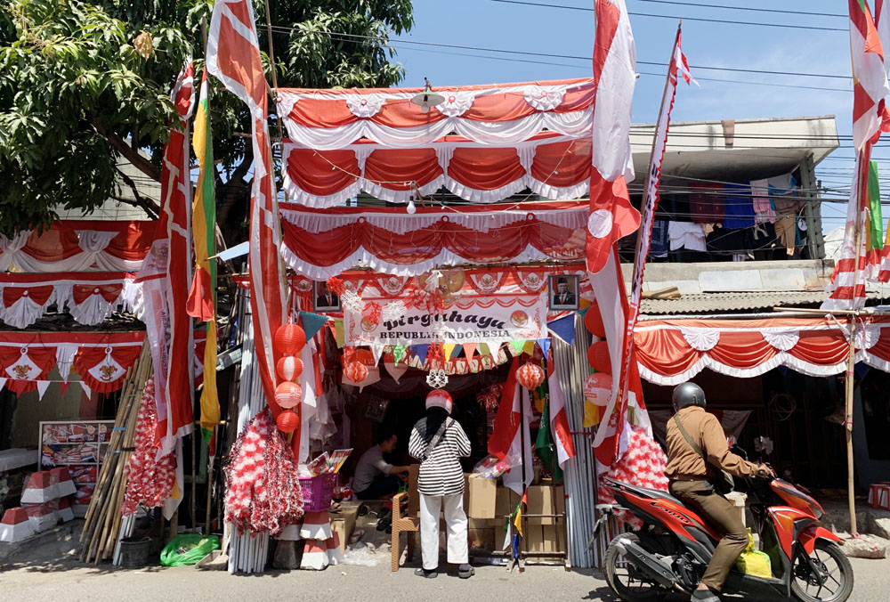 Salah satu lapak pedagang yang berjualan aneka bentuk dan ukuran bendera merah putih dan atributnya di Kampung Bendera, Darmokali, Surabaya. (INDHIRA AYU/RADAR SURABAYA)