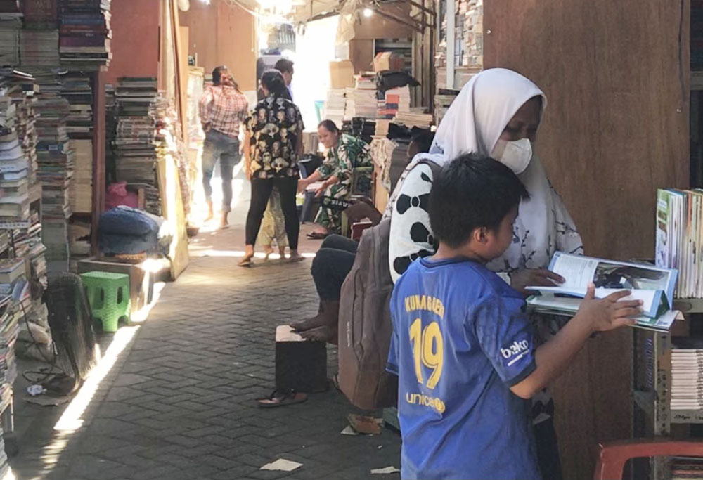 PENDIDIKAN DINI: Seorang anak dan ibunya membeli buku di Kampung Ilmu. Mencintai buku bisa diajarkan sejak dini. (INDHIRA AYU/RADAR SURABAYA)