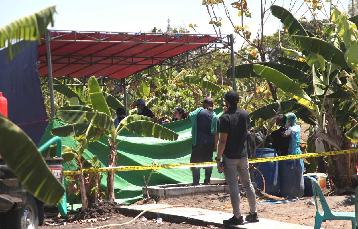 EKSHUMASI: Petugas membongkar makam Ervin di TPU Kendung, Sememi, Surabaya. (SURYANTO/RADAR SURABAYA)