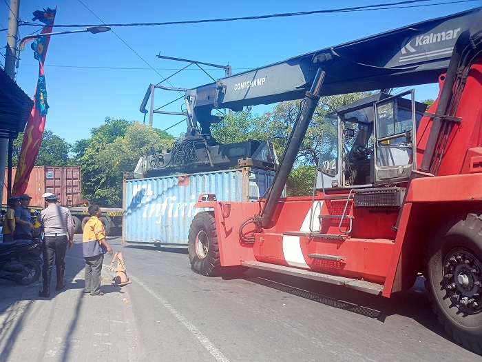 BERAT: Evakuasi truk yang gagal menanjak di Jembatan Petekan, Surabaya, polisi harus menggunakan alat berat (kalmar) untuk memindahkan satu kontainer agar truk bisa melaju. (GUNTUR I/RADAR SURABAYA)