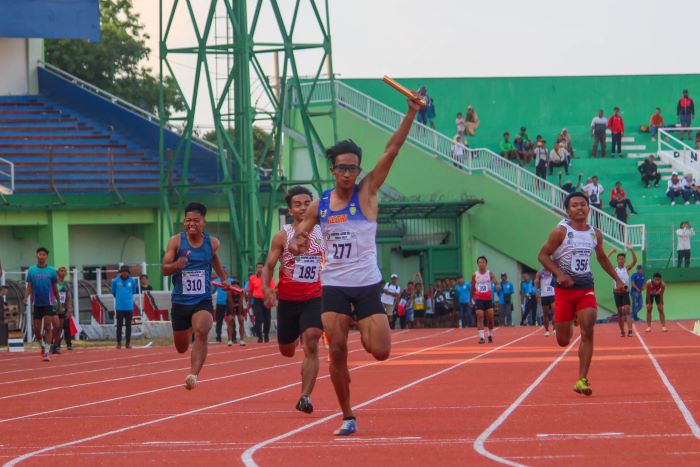 JUARA: Fariz Agung sprinter Kota Kediri memimpin rekan-rekannya tercepat di nomor estafet. (JAWAPOS)