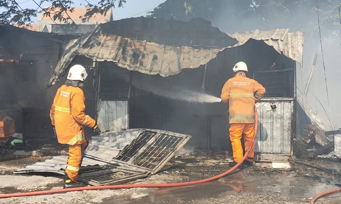 GERCEP: Petugas dengan cepat memadamkan kebakarn tiga warung di Jalan Kertomenanggal, Kelurahan Menanggal Gayungan, Surabaya, Minggu siang (17/9).  (MAHRUS/RADAR SURABAYA)