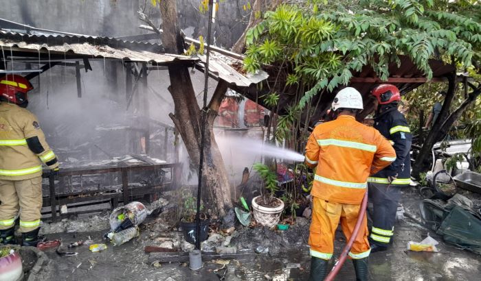TINGGAL PUING: Petugas DPKP melakukan pembasahan di bangunan yang terbakar di Jalan Bumi Wonorejo Asri. (IST)