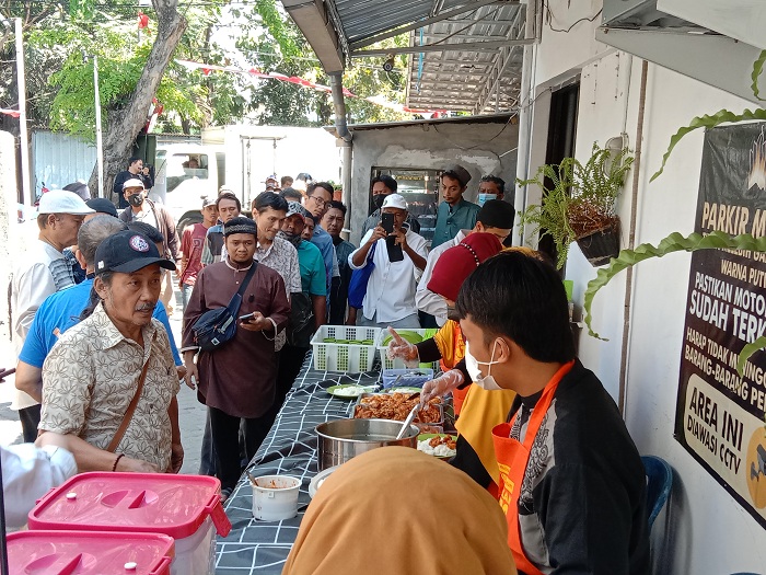 ANTRE: Masyarakat sekitar saat mengantre untuk mendapatkan makan siang gratis di kawasan Kalikepiting, Surabaya, Senin (18/9). (RAHMAT SUDRAJAT/RADAR SURABAYA)