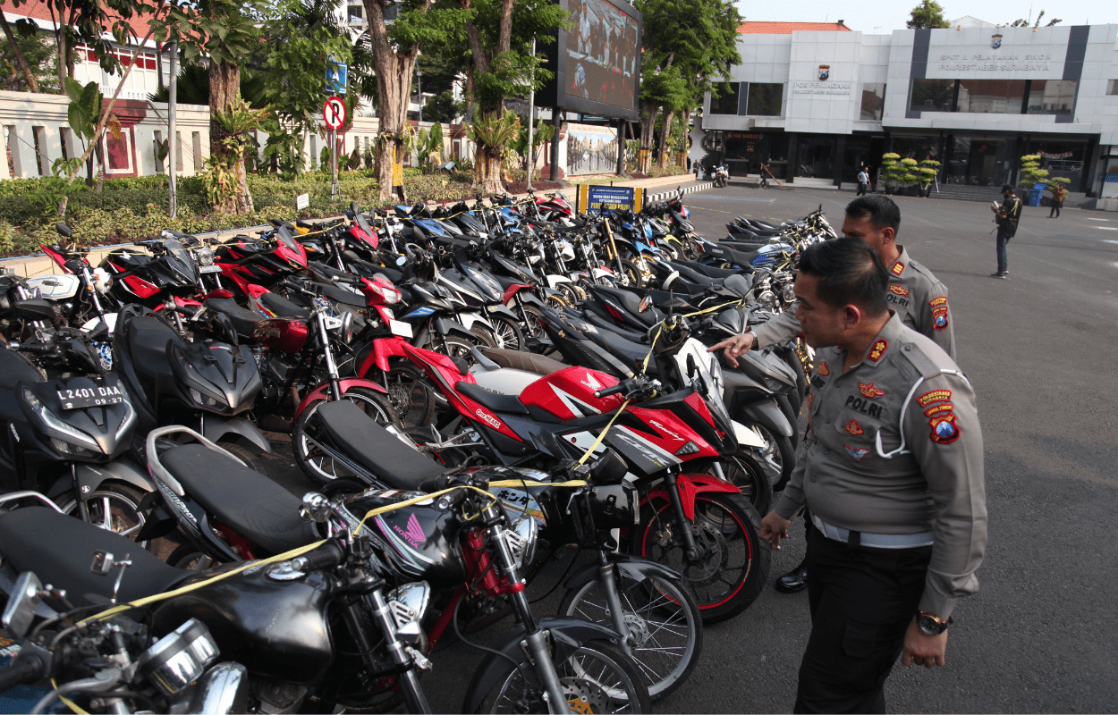 BARANG BUKTI: Petugas mengamati ratusan motor yang terjaring razia dan diamankan di Mapolrestabes Surabaya, Senin (18/9). (SURYANTO/RADAR SURABAYA)