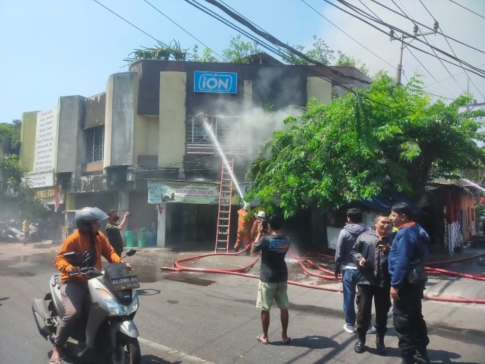 PEMADAMAN: Petugas melakukan pemadaman terhadap ruko laundry di Jalan Kapasan yang terbakar, Sabtu (23/9). (IST/RADAR SURABAYA)