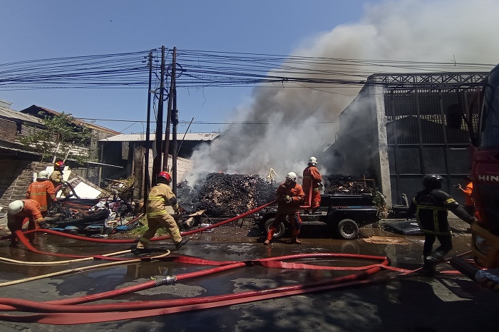 BERJIBAKU: Petugas berusaha memadamkan api saat terjadi kebakaran di gedung gudang barang bekas di Jalan Raya Pandugo, Surabaya, Rabu 927/9). (SURYANTO/RADAR SURABAYA).
