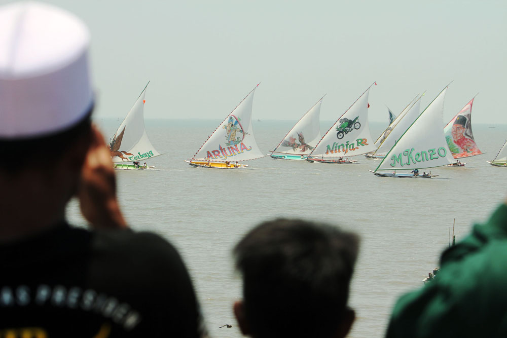 PUTARAN FINAL: Sejumlah finalis balap perahu layar beradu cepat dalam lomba perahu tradisional di perairan Kenjeran, Surabaya,  Minggu (1/10). (ANDY SATRIA/RADAR SURABAYA)
